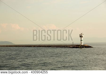 Beautiful Seascape With Lighthouse. Calm Sea And A Lighthouse On The Pier. Small Beacon In The Endle