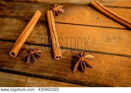 CINNAMON STICKS ON WOODEN BACKGROUND