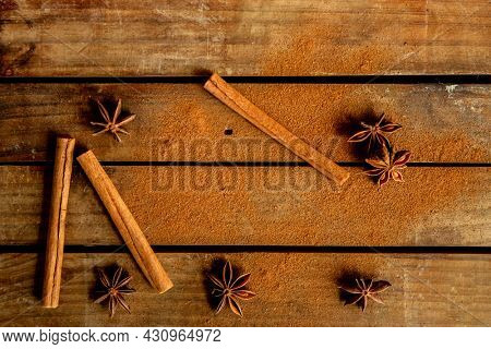 CINNAMON STICKS ON WOODEN BACKGROUND