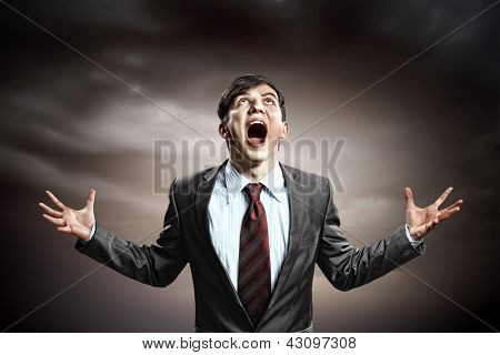 businessman in anger with fists clenched screaming