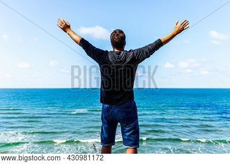 Caucasian Man Spreading Arms And Watching The Ocean. Happy Man With Outstretched Arms.man With His A