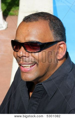 A Successful And Happy African American Man Sitting At His Pool