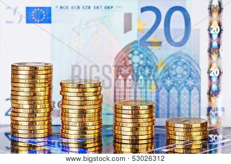 Downtrend Stacks Of Golden Coins And Euro Banknote As Background. Selective Focus