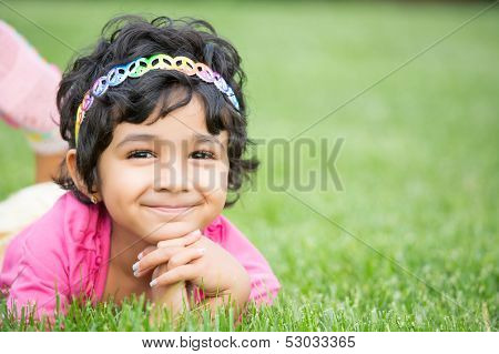 Portrait Of A Smiling Child On Green Grass