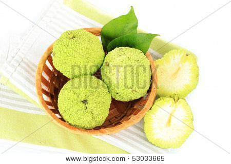 Osage Orange fruits (Maclura pomifera) in basket, isolated on white