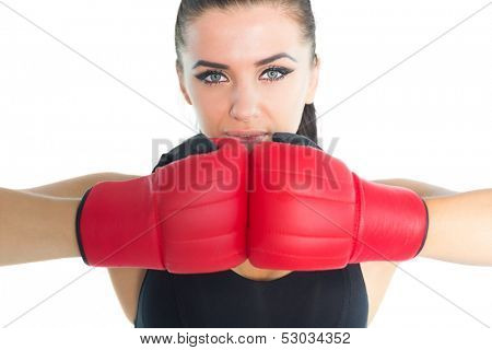 Gorgeous sporty woman posing wearing boxing gloves looking at camera