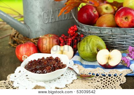 Juicy apples in basket on table on natural background
