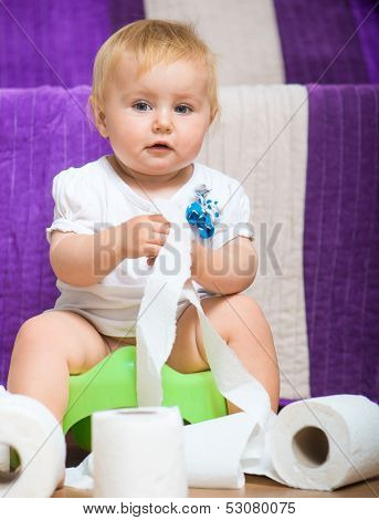 adorable baby on the potty with toilet paper