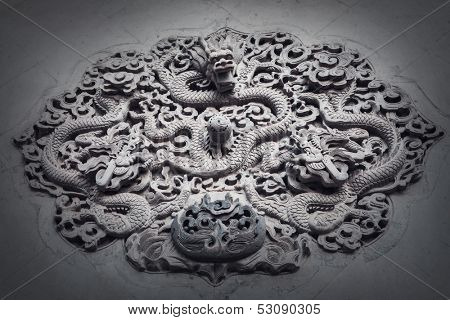 Ornate low relief sculpture of dragon on wall.
