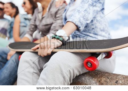 acticity and summer holiday concept - close up of female hand holding skateboard