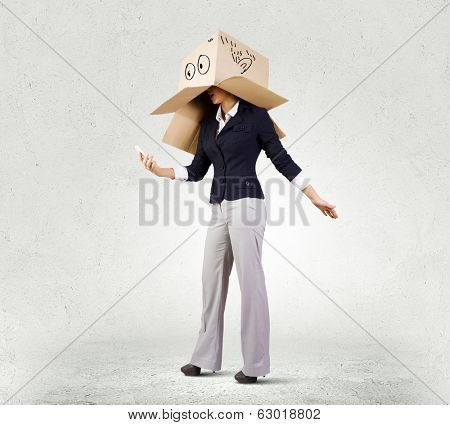 Businesswoman using mobile phone wearing carton box on head