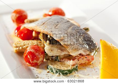 Fillet of Seabass with Tomato and Mussels Sauce. Garnished with Vegetables