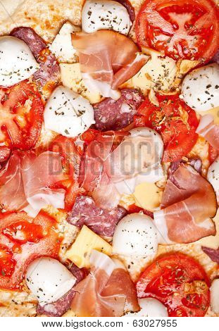 Raw pizza dough with mozzarella and proscuitto on top