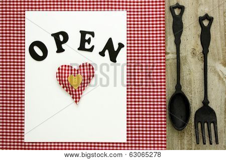 Open sign with cast iron spoon and fork