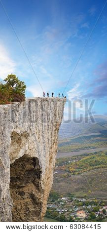 People on a steep high rock