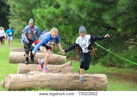 MUSKOGEE, OK - Sept. 13: Athletes jump over obstacles during the Castle Zombie Run at the Castle of Muskogee in Muskogee, OK on September 13, 2014. 
