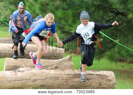 MUSKOGEE, OK - Sept. 13: Athletes jump over obstacles during the Castle Zombie Run at the Castle of Muskogee in Muskogee, OK on September 13, 2014. 
