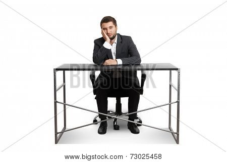 wearied businessman sitting at table and looking at camera. isolated on white background