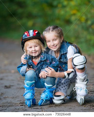 Two little girls rollerskating in the park outdoor