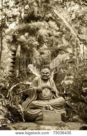Old ruined Arhat Kanakbharadvaja statue in forest, Taiwan, Asia.