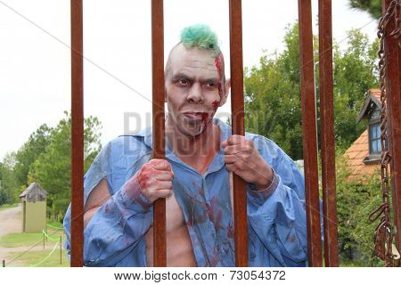 MUSKOGEE, OK - Sept. 13: Bloodied actor scares runners during the Castle Zombie Run at the Castle of Muskogee in Muskogee, OK on September 13, 2014. 