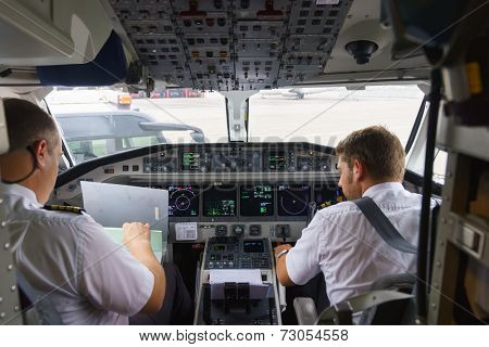 GENEVA - SEPTEMBER 11: Etihad Regional pilots in aircraft cockpit on September 11, 2014 in Geneva, Switzerland. Darwin Airline, operating under the brand name Etihad Regional since January 2014