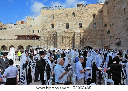 JERUSALEM, ISRAEL - SEPTEMBER 20, 2013:The Western Wall of the Temple in Jerusalem. Morning Sukkot. Many religious Jews in traditional robes tallit gathered for prayer.