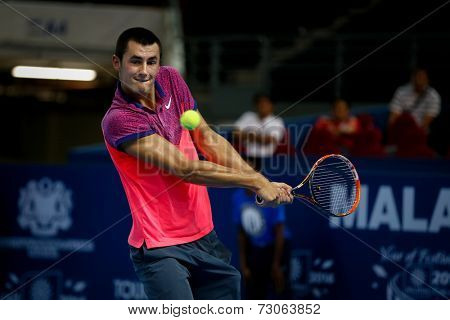 SEPTEMBER 23, 2014 - KUALA LUMPUR, MALAYSIA: Bernard Tomic of Australia makes a backhand return in his first round match at the Malaysian Open Tennis 2014 event. This is an ATP sanctioned tournament.