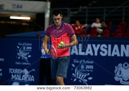 SEPTEMBER 23, 2014 - KUALA LUMPUR, MALAYSIA: Bernard Tomic of Australia prepares to make a serve in his first round match at the Malaysian Open Tennis 2014 event. This is an ATP sanctioned tournament.