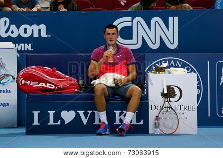 SEPTEMBER 23, 2014 - KUALA LUMPUR, MALAYSIA: Bernard Tomic of Australia takes a drink at game break in his match at the Malaysian Open Tennis 2014 event. This is an ATP sanctioned tournament.