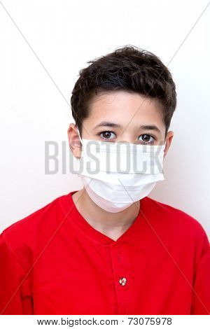 A sick young boy with face mask on.