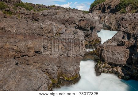 Barnafoss is a dangerous Icelandic waterfall in the west of the island. It is formed by Hvita river going through a narrow canyon. 
