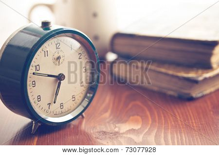 analog retro alarm clock on wooden table