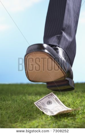 Podnikatel na padesát dolarové bankovky v trávě detail nohy