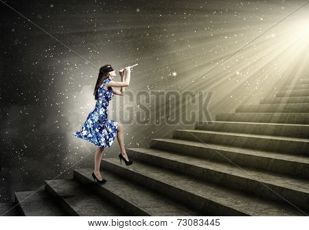 Young woman in blue dress wearing blindfold playing fife