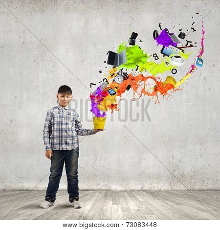 Young boy splashing colorful paint from bucket