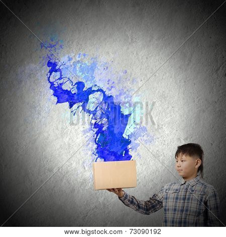 Young boy splashing colorful paint from carton box