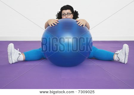 Mujer con sobrepeso sin inspiración sentada detrás de la pelota de ejercicios