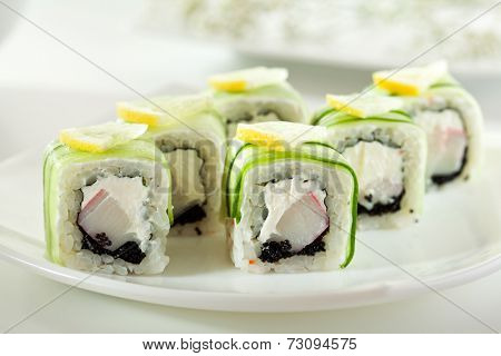 Cucumber Maki Sushi  - Roll made of Crab Meat, Cream Cheese and Black Tobiko inside. Cucumber outside. Topped with Lemon Slice