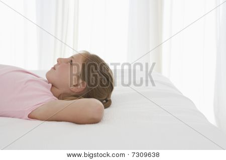 Mädchen auf dem Bett liegend profile halblange