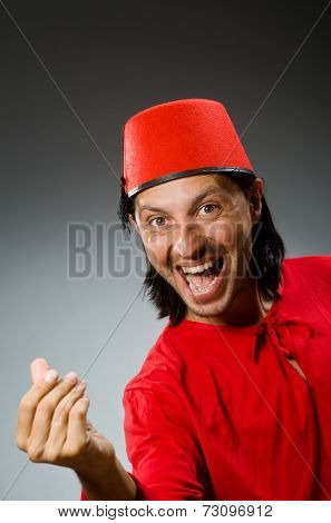 Man in red dress wearing fez hat