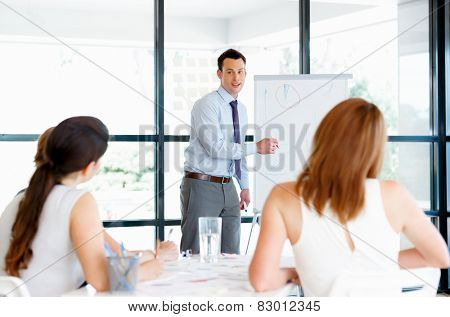 Businessman doing a presentaion in front of his collegues