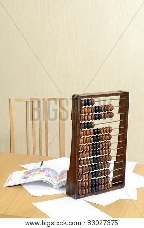 Workplace accountants desk, chair, arithmetical abacus, sheets of paper and a pen