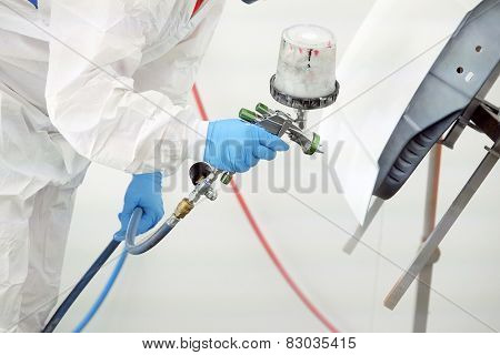 Automobile repairman painter paints the details for body repair