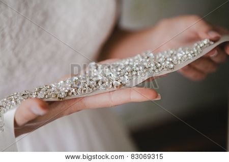 Bride holding a belt with rhinestones. wedding accessories