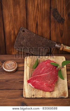 raw beef meat fillet  on wooden  table with meat cleaver and 1lb iron weight