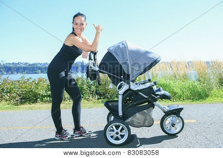 A Young mother jogging with a baby buggy