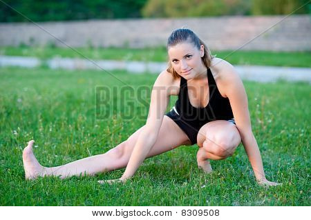 Cute adolescente s'étend ses jambes sur une grasss vert