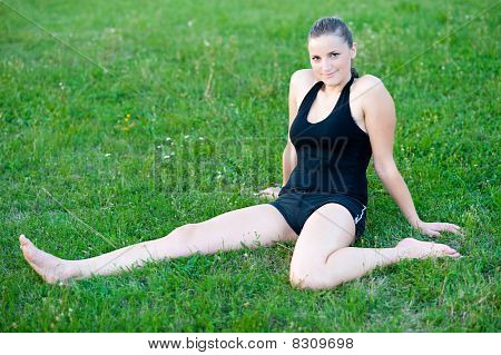 Cute adolescente s'étend ses jambes sur une grasss vert