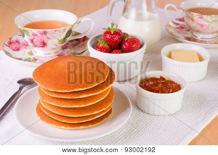 Stack Of Pancakes With Fresh Strawberries; Butter, Marmelade, And Tea